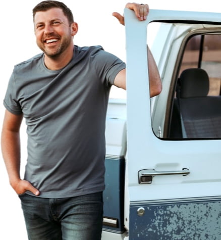 Levi Riggs stands next to the open door of a pickup truck